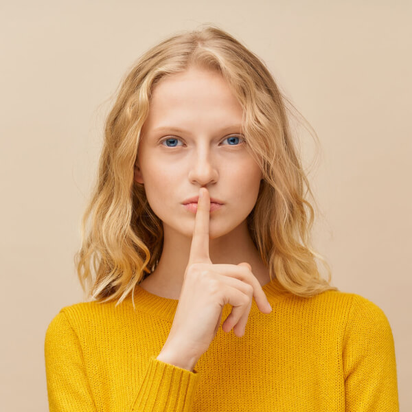 waist-up-portrait-of-woman-putting-finger-to-lips-Q4GRUTL-1